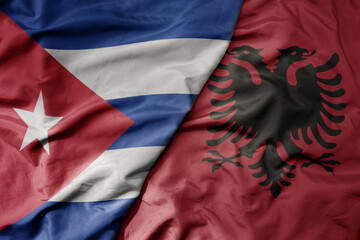 big waving national colorful flag of albania and national flag of cuba .