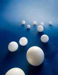 minimalistic composition of white sphere sculptures in a simple blue background, contemporary art