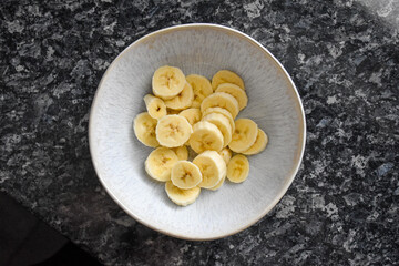 Ceramic bowl with sliced banana.