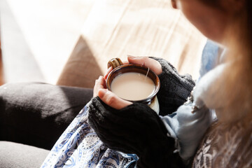 Woman holding warm mug of chai tea in winter