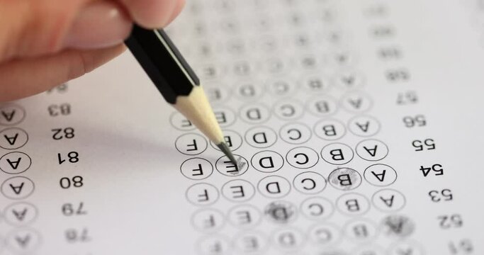 Student takes test highlighting answer with pencil