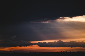 dark clouds gather on top of a city in the distance