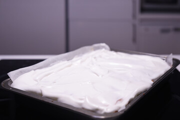 Baking of traditional roll apple cake with nuts, raisins and cinnamon covered with egg white snow