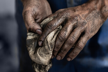 Dirty male hands with a towel after car repair close-up.