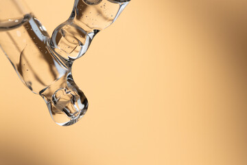Two glass droppers with hyaluronic acid on a beige background, front view.