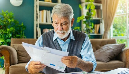 senior person reading a letter; old man reading a bill and trying to understand the content of it 