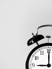Monochrome background with retro alarm clock at 9 nine o clock with copy space to add text. 9am 9pm