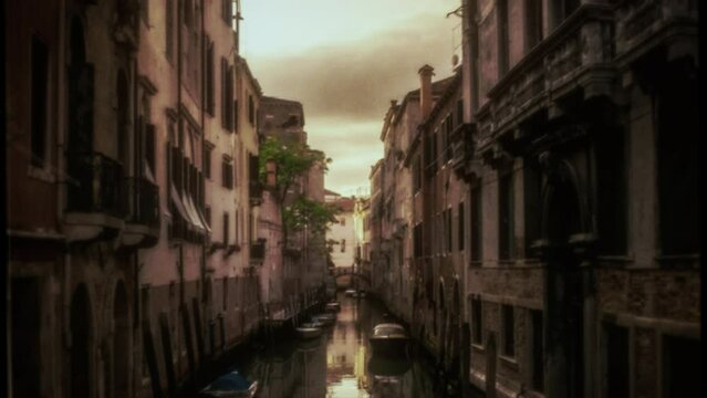 Venice Canal Vintage Style Old Film Texture Tracking Shot. Camera going through a Venice canal during sunset, vintage film effect. Tracking shot