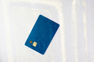 Closeup of a dark blue credit card isolated on an empty surface