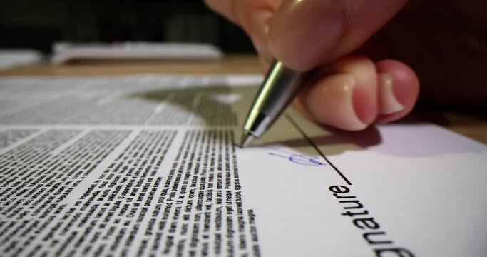 Woman signs and dates sheet of paper with printed contract