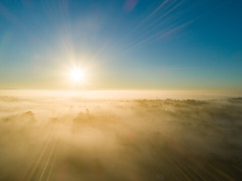Golden sunrise over landscape of fog and mist
