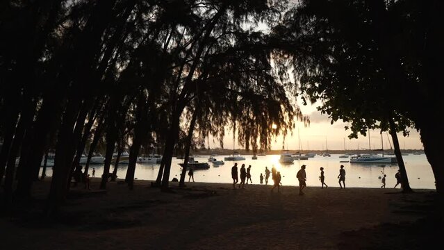 View of football match on beach and boats in Grand Bay at sunset, Grand Bay, Mauritius, Africa
