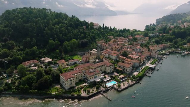 Drone shot over Como lake with view of Bellagio town and forested hill