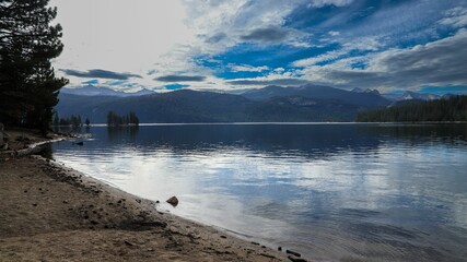 Scenic view of a tranquil lake surrounded by green pine trees and mountains