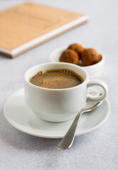 A cup of coffee, truffle sweets and a notepad for notes. Morning ritual.