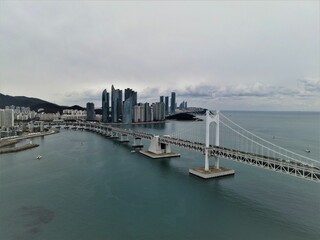 Obraz premium Aerial view of the Busan skyline with the Gwangan Bridge crossing over the sea, South Korea