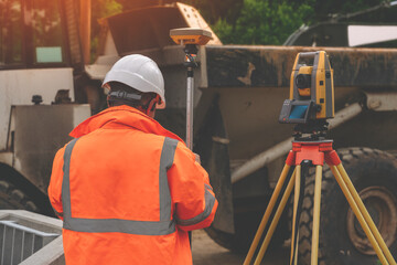 Surveyor site engineer with total positioning station on the construction site of the new road...
