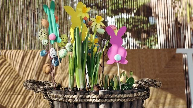 spring Easter composition with yellow flowers, paper colored Easter bunny, eggs basket. prepare decoration present for Easter party at home. creativity and hobby DIY