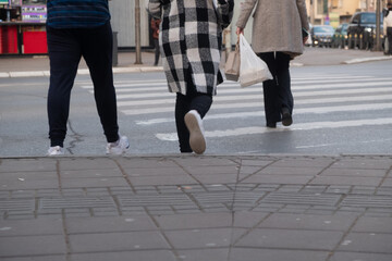 People crossing the street in the city, closeup of legs and shoes 