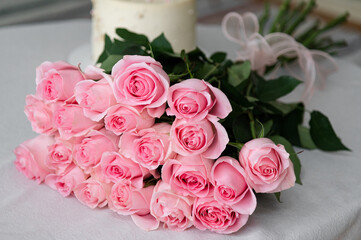 A beautiful large bouquet of roses. The flowers are pink. Bouquet on the table. Real situation