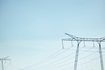 Low angle view of electricity pylon against blue sky