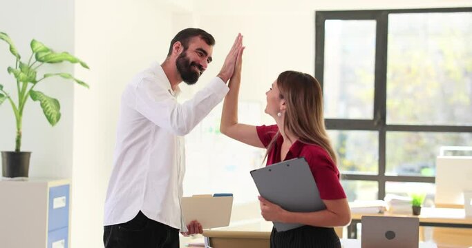 Positive man and woman express agreement giving high-five