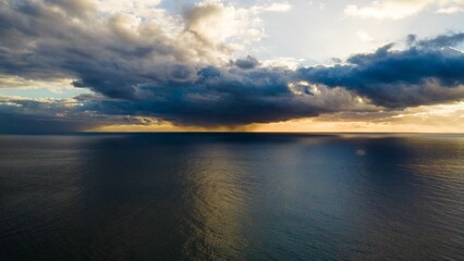 Beautiful ocean landscape with a clear sky and  fluffy clouds illuminated by a bright and warm sun