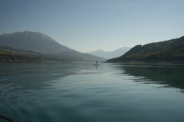 Tranquil lake in a mountains, creating a reflection of the surrounding terrain on the still waters