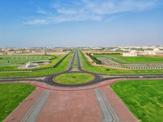 Scenic aerial view of a long and winding road surrounded by open fields located near the city