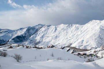 Fototapeta na wymiar Scenic winter landscape featuring a snow-covered mountain range with a valley below