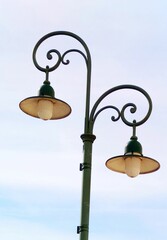 Green streetlight with two separate lights suspended from the frame