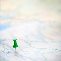 Green thumbtack marking and showing destination location point on map background with copy space