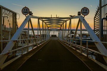 a bridge with traffic signs at dusk near the water's edge