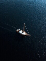 Sailboat peacefully gliding across the vast dark blue ocean