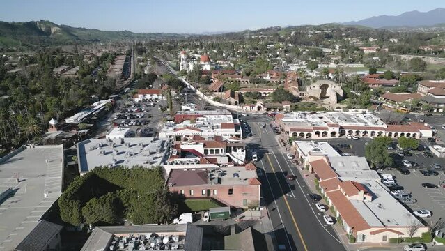 Drone view over Serra Chapel and other buildings surrounded by vegetation in San Juan Capistrano