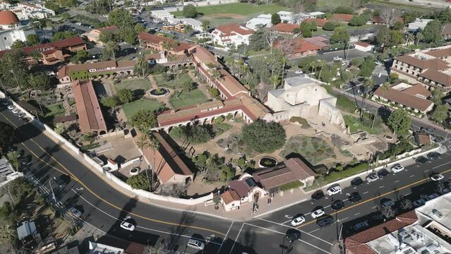 Drone view over Serra Chapel and other buildings surrounded by vegetation in San Juan Capistrano