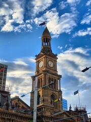 Fototapeta na wymiar Sydney Town Hall building on the background of the cloudy sky