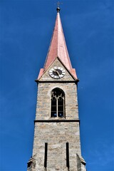 Old brick clock tower on the background of the bright blue sky