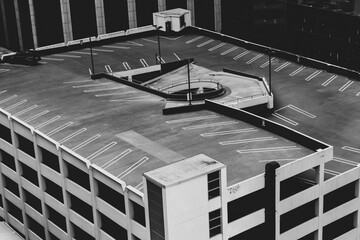 Parking lot on the roof of the building with one parked car. - obrazy, fototapety, plakaty