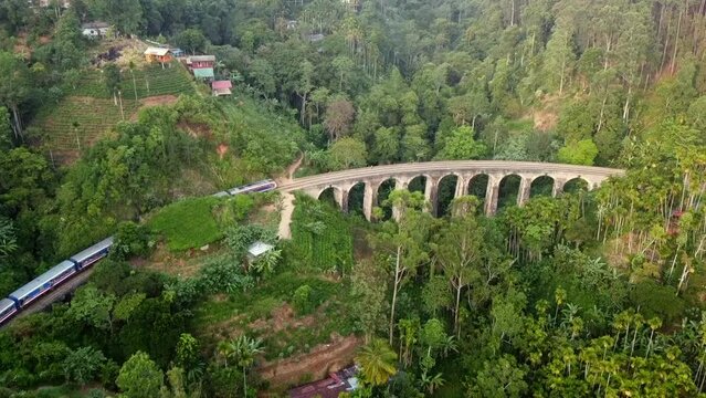 Drone view over the Nine Arches Bridge surrounded by green vegetation in Sri Lanka
