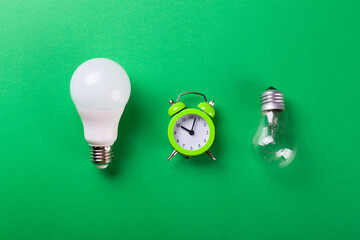 incandescent lamp and led lamps against on isolated green background. Energy efficiency concept....