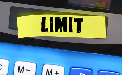 LIMIT word on a small yellow sheet of paper placed on a calculator.