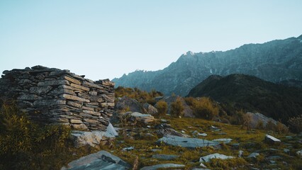 Top of a hill with a majestic mountain range in the background