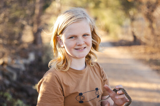 Pre-teen adolescent boy holding pet children's python snake