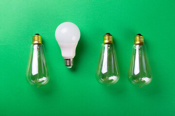 Led lamp or three incandescent eddison lamp on green background. Flat lay. Concept ecology, save...