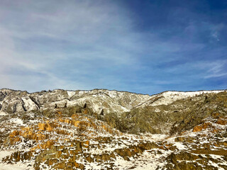 Yellow-green snow-capped mountains against a cloudy sky