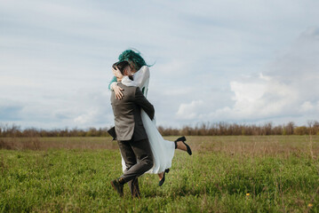 a bearded groom and a girl with green hair dance and twirl