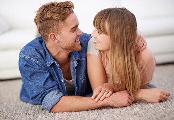Couple, hug and together on floor of living room with smile and affection, happiness or love for...