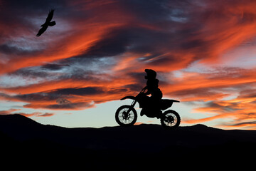 Obraz na płótnie Canvas Silhouette of motocross rider at sunset. Extreme sports and twilight.