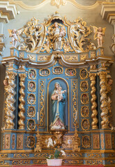COURMAYEUR, ITALY - JULY 12, 2022:  The baroque altar with the carved polychrome satatue of Madonna in the church Chiesa di San Pantaleone  - 731762049